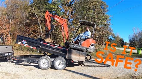 loading a mini excavator into a dump truck|loading mini excavators into dump trailer.